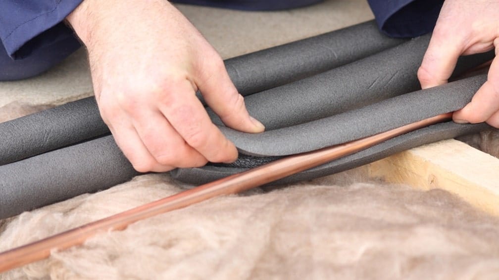 homeowner adds insulation to pipes
